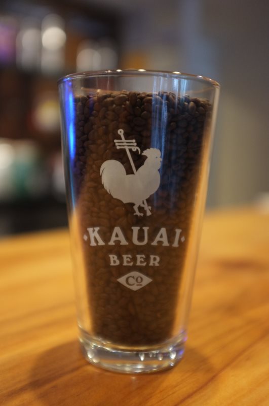 Satin etched Kauai Beer Co. pint glass filled with malt