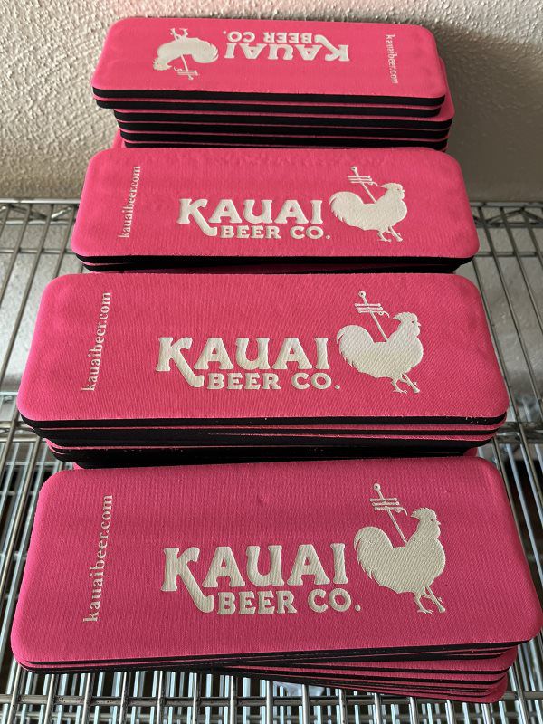 Stacks of pink Kauai Beer Co. slap koozies
